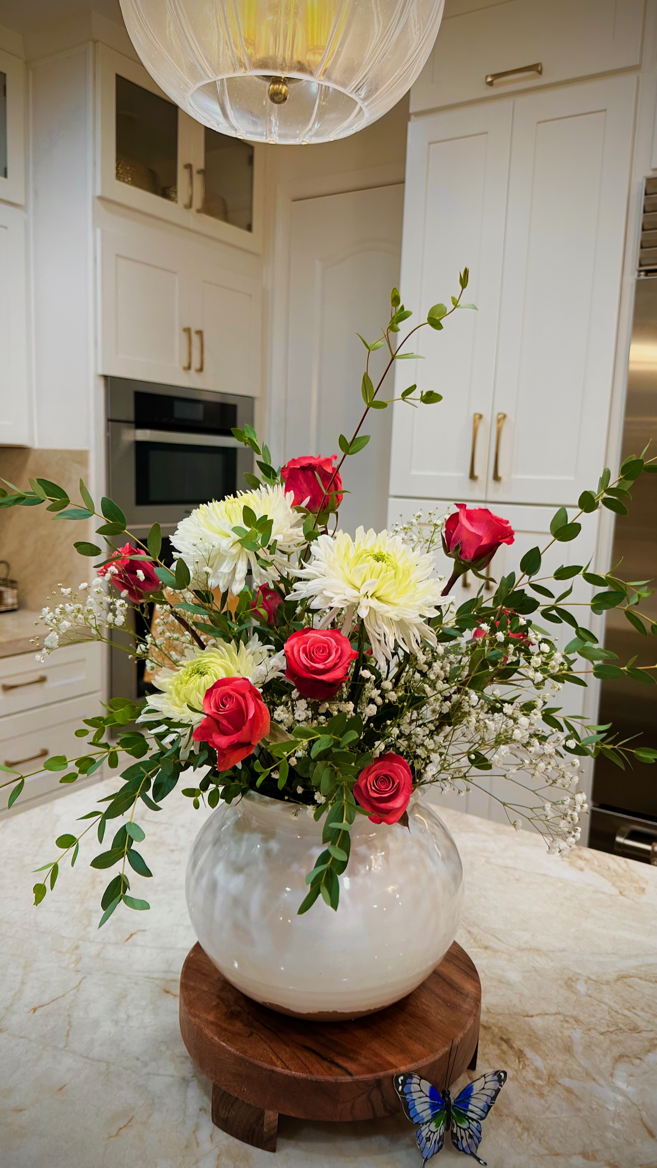 Pink peonies and roses in a white vase